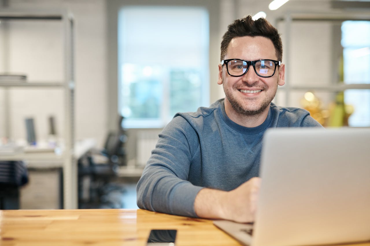 smiling man with a laptop computer